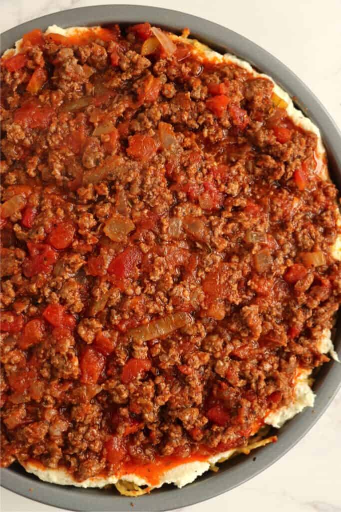 Overehad shot of unbaked spaghetti pie with no cheese. 