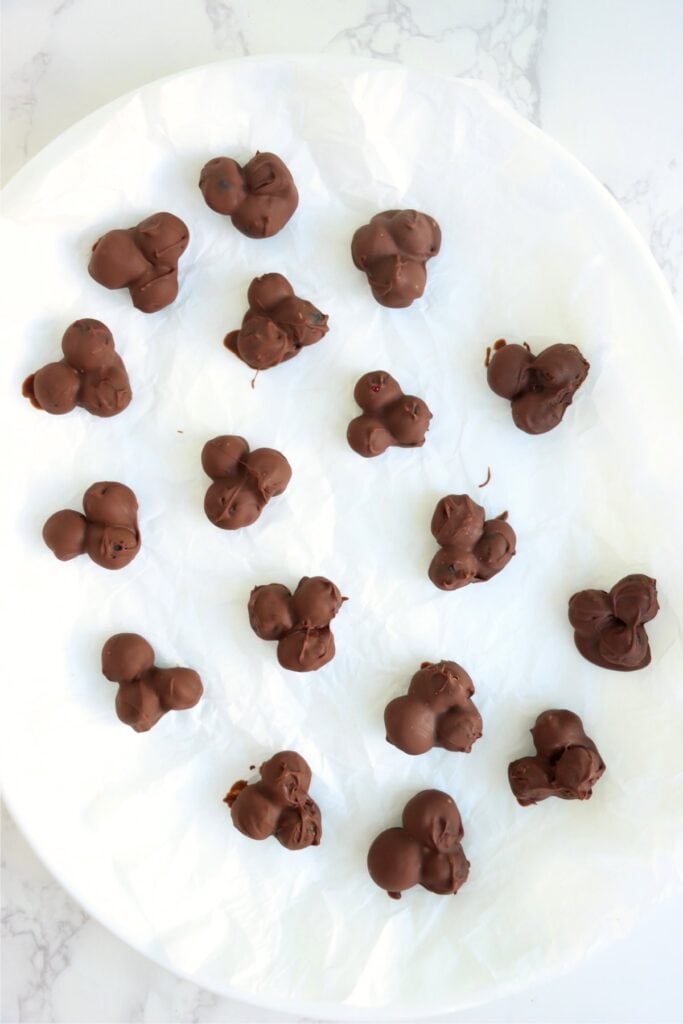 Overhead shot of chocolate covered blueberry clusters on parchment paper