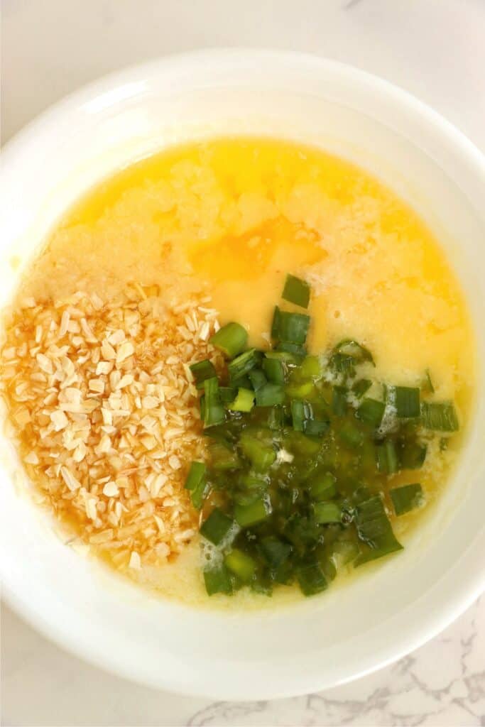 Closeup shot of bowlful of melted butter and seasonings. 