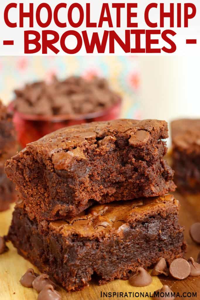 Closeup shot of two chocolate chip brownies stacked atop one another with bite taken out of the top brownie. 