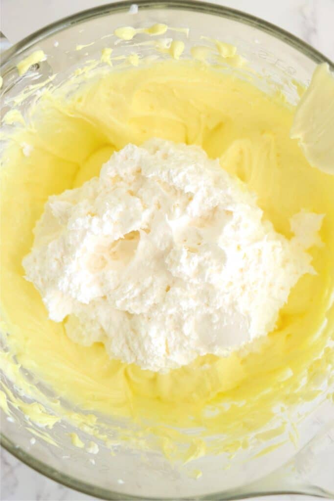 Closeup overhead shot of bowlful of lemonade cream chees mixture topped with whipped topping.
