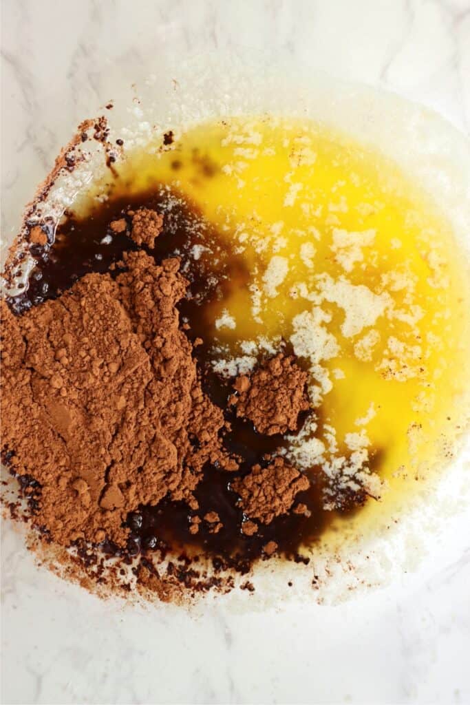 Closeup overhead shot of melted butter, cocoa powder, and vanilla. 