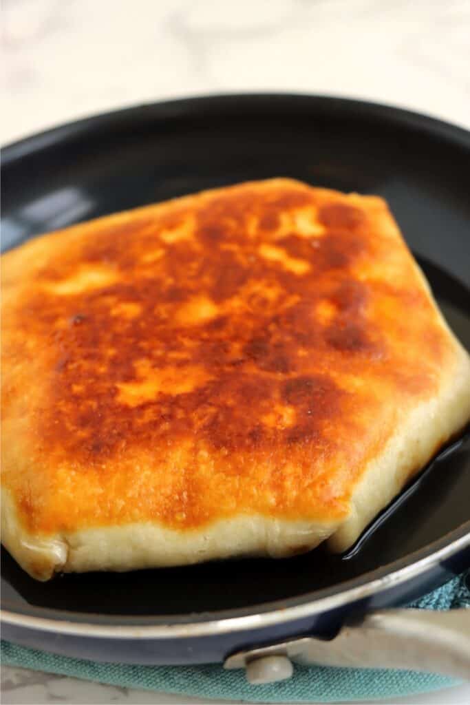 Closeup shot of toasted crunch wrap in skillet. 