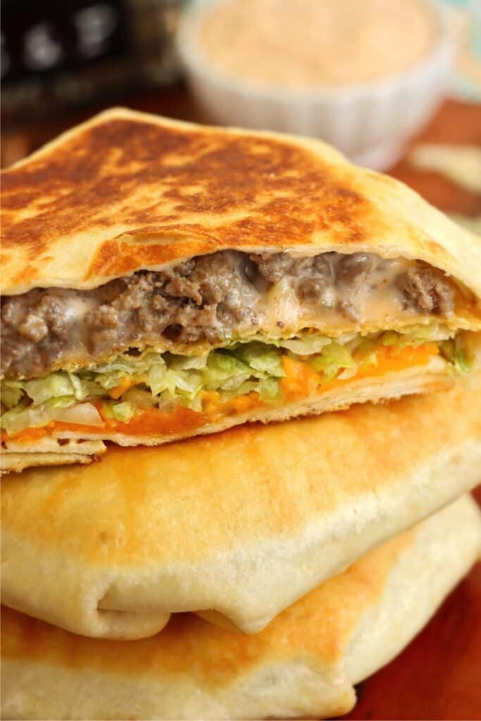 Closeup shot of Big Mac crunch wraps stacked atop one another. 