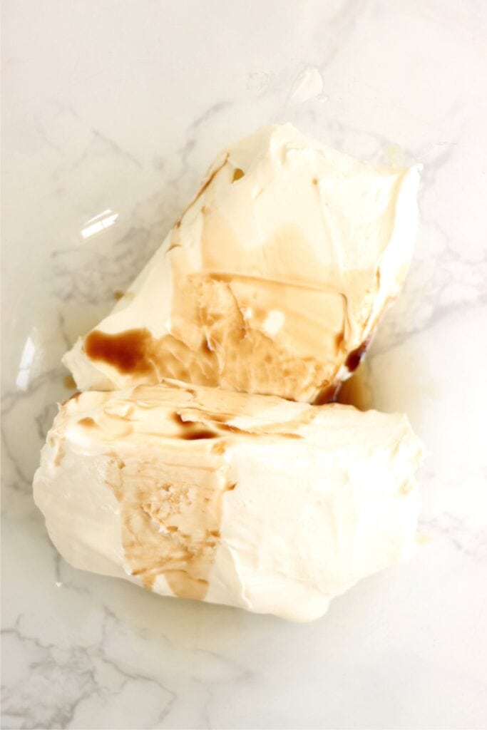 Closeup shot of mixing bowl with cream cheese and vanilla. 