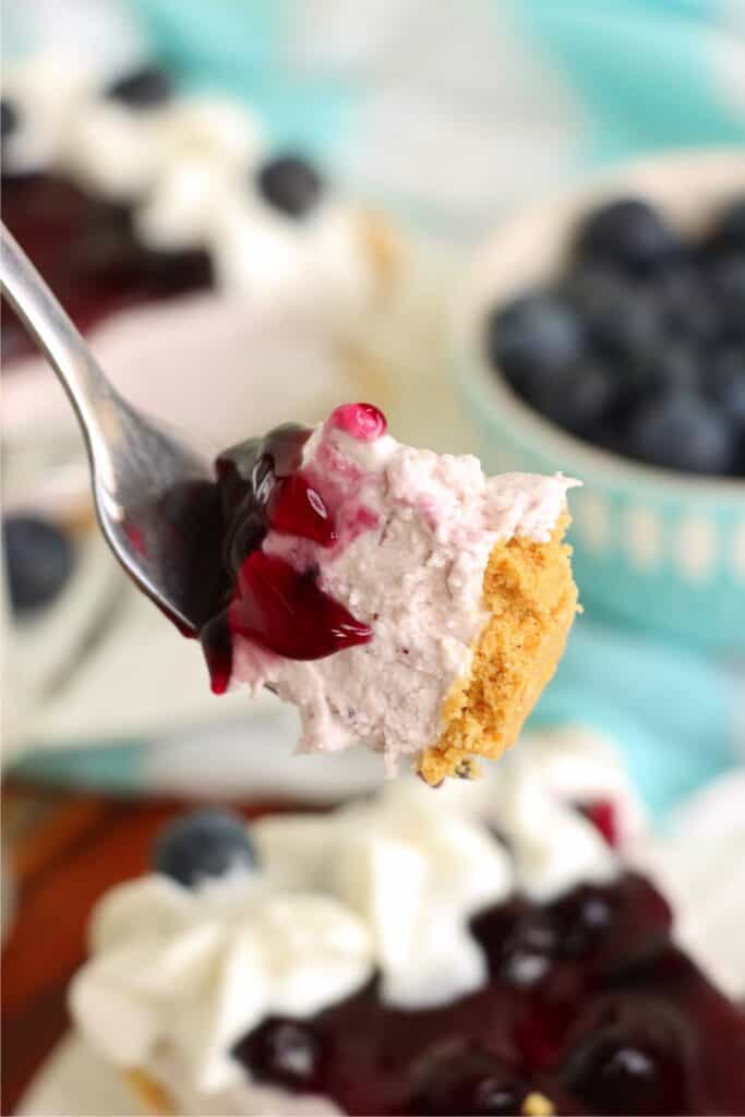 Closeup shot of forkful of blueberry cream cheese pie.