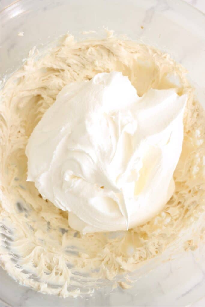 Overhead shot of creamed cream cheese and with whipped cream on top. 
