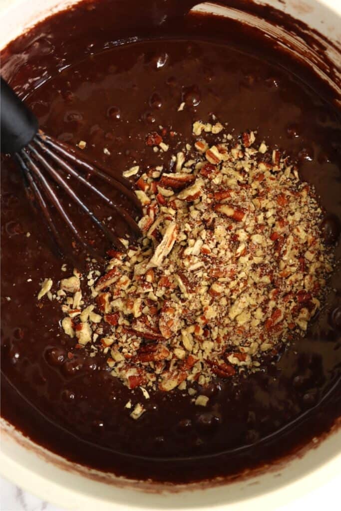 Overhead shot of brownie batter with chopped pecans. 