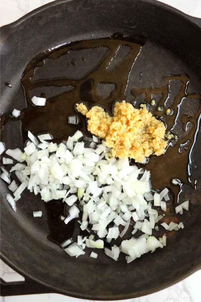 Closeup overhead shot of onions and garlic cooking in skillet