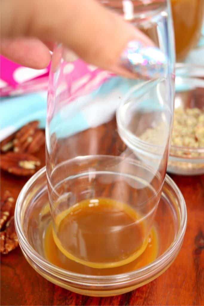 Rim of glass being dipping in caramel sauce. 